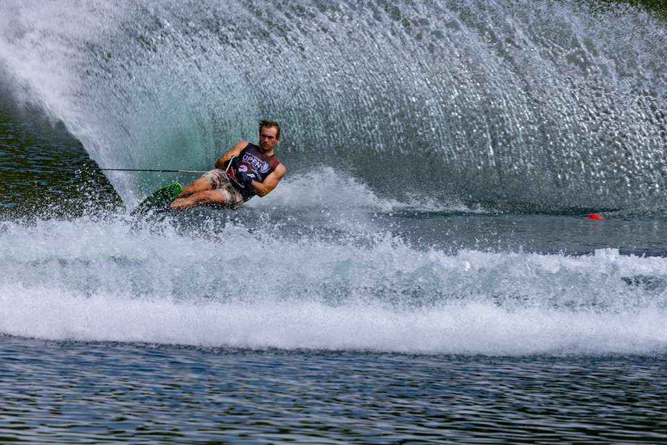 Sunlit wall of spray behind a hard slalom cut